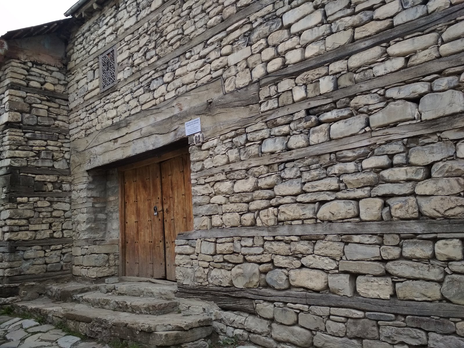 Lahıcda XIX əsrə aid Hacıağa Sultanovun evi: daş və taxta tirlərlə hörülmüş divar, köhnə taxta qapı